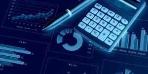 Calculator and pen sitting ontop of graphs and reports