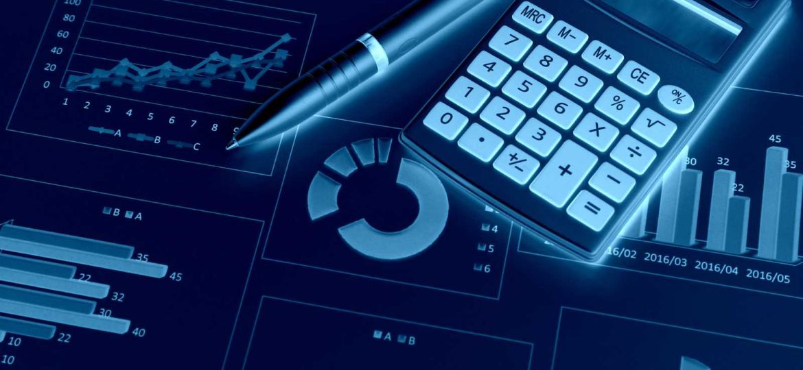 Calculator and pen sitting ontop of graphs and reports