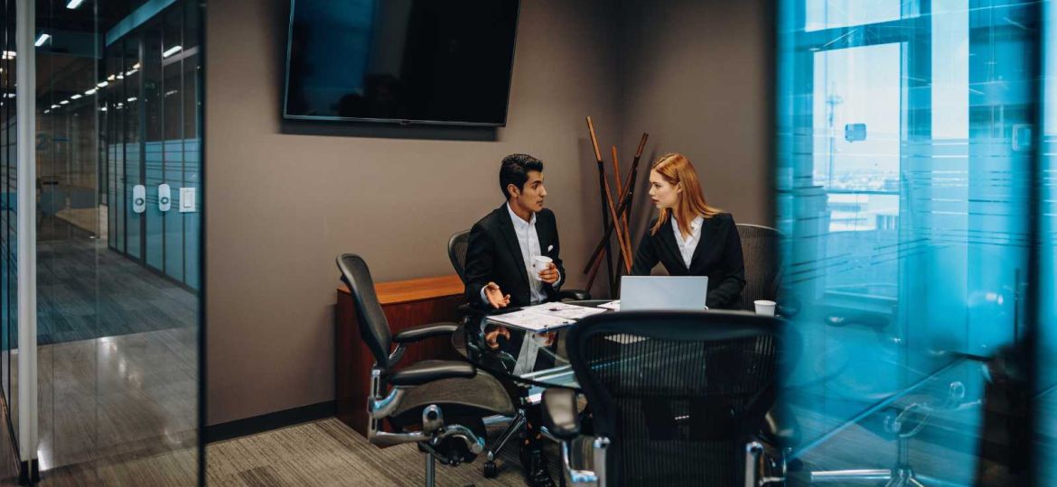 Employees sitting in conference room talking