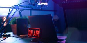 TV broadcasting on air sign in front of laptop on desk